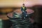 Miniature people Businessman sitting on coin stack warm background. Success Concept. Macro