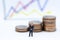 Miniature people: Businessman stand front of dashboard, display graphs, profit margins of background. Image use for business