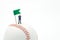 Miniature people businessmen standing with Green Flag Pin on baseball on a white background and red stitching baseball. as backgro