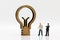 Miniature people: Businessmen standing with lamp idea symbol, Concept of Finance, investment and growth in business