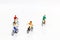 Miniature people enjoy riding a bicycle on white background