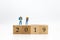 Miniature people, group travelers standing on wooden block 2019, new year. Image use for travel business concept.