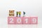 Miniature people, group travelers standing on wooden block 2019, new year. Image use for travel business concept.