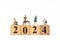 Miniature people , A joyful family enjoys New Year\'s celebrations with wooden block 2024