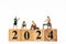 Miniature people , A joyful family enjoys New Year\'s celebrations with wooden block 2024