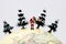 Miniature people: Santa Claus standing on globe with tree.
