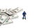 Miniature people toy figure photography. Money transfer security concept. A police officer standing beside money cargo pallet.