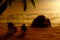 Miniature people toy figure photography. Silhouette of men and girl couple relaxing on beach chair when sunset at seaside