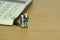 Miniature people toys conceptual photography. Elderly couple standing in front of calculator