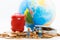 Miniature people : Travelers stand on a pile of coins and have a red suitcase, world map for background. Image use for travel,