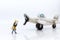 Miniature people: Workers prepare equipment for maintenance of the plane. Image use for treatment, business concept