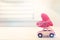 Miniature pink car carrying heart cushion