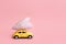 Miniature pink and yellow cars carrying heart cushions. Minimal concept