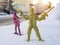 Miniature plastic toy soldier targeting gun on other enemy toy soldier and taking as hostage on snow. Soldier surrendering in wa