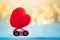 Miniature red car carrying a red heart on shine bokeh background