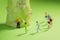 Miniature Runners jogging in a circle around a broccoli to train fitness and endurance