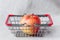 A miniature shopping basket and a red apple in it