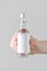 Miniature Spirits / Liquor Bottle Mock-Up. Blank Label - Male hands holding a liquor bottle on a gray background