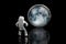 Miniature steel spaceman looking at the Moon. Close-up shot, isolated on black, selective focus