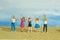Miniature tiny people toys photography. Group of teens raised hand or hands up celebration at the beach