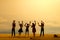 Miniature tiny people toys photography. Silhouette group of teens raised hand or hands up celebration on sunset time at the beach