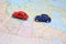 Miniature toy cars driving in tandem on a map of canada