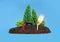 Miniature toy forest setup with a tiny fire extinguisher next to a burning match