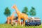 Miniature toys of a group of people on safari trip watching giraffes - a hunter, father and son on shoulder ride, photographer