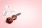 Miniature violin with music hearts and copy space on pink background