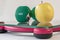 Miniature woman figure standing on the digital electronic bathroom scale for weight of human body. Fresh apple and green dumbbells