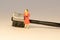 Miniature woman in orange dress next to black brow lash groomer brush. Beauty and Skin care concept