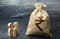 Miniature wooden family figurines stand near a money bag. The concept of savings. Budget planning. Family income. Distribution of