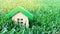 Miniature wooden house on grass. Real estate concept. Eco-friendly and energy efficient house. Buying a home outside the city. The