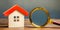 Miniature wooden house and magnifying glass. Home appraisal. Property valuation. Choice of location for the construction. House