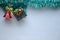 Miniature wooden sledge carrying a small gift next to a decorative Christmas tree made of wood with a little squirrel on a green