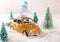 Miniature yellow car with spruce trees