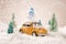 Miniature yellow car with spruce trees