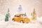 Miniature yellow car with spruce trees