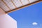 Minimal architecture background of arcade roof with beige building against blue sky in bottom view