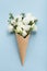 Minimal composition with creative ice cream of beautiful flowers on blue pastel paper top view. Flat lay style.