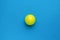 Minimal concept of a large tennis ball on a blue background. Flat lay