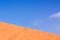 Minimal desert landscape background scenic view diagonal horizon background of yellow sand dune foreground and blue sky space