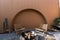 Minimal empty space scene with brown painted wall and  rattan armchair and artificial cactus with rock setting  in natural light