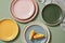 Minimal flat-lay of slice Orange on colorful plates with linens napkins