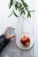 Minimal healthy snack concept. The child`s hands are holding an apple and a glass of water. Still life on a light wooden table wit