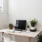 Minimal home-office with open blank screen laptop computer and office supplies on white wooden table