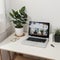 Minimal home-office with open blank screen laptop computer and office supplies on white wooden table