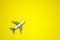 Minimal layout with model airplane on yellow background. Directly above. Travel vacation summer concept. flat lay, top view