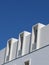 Minimal lines of modern white building against saturated blue sky. Lined minimalistic architecture. Vertical photo