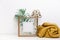 Minimal Mock up wooden frame with green tropical leaves and trendy warm sweater